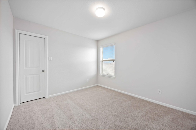 empty room with baseboards and carpet