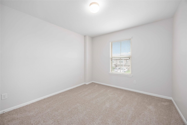 spare room with carpet flooring and baseboards
