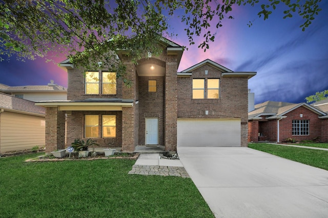 traditional-style house with brick siding, an attached garage, driveway, and a front lawn
