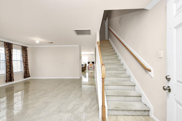 stairway featuring baseboards, ornamental molding, and visible vents