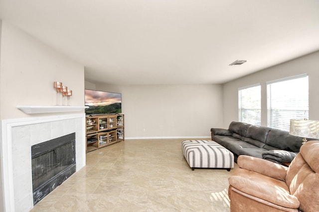 living room featuring visible vents, baseboards, and a fireplace