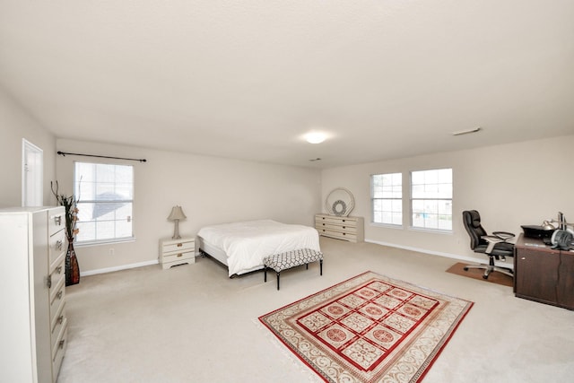 bedroom featuring light colored carpet, baseboards, and multiple windows