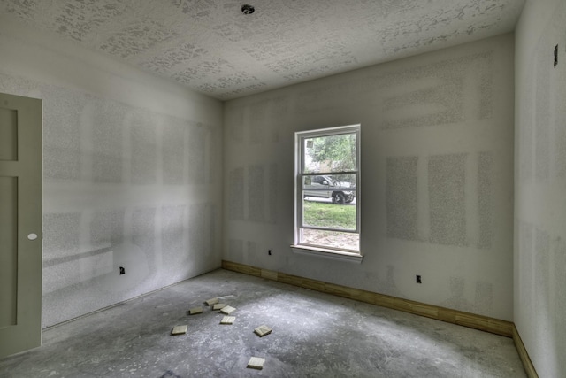 spare room with baseboards