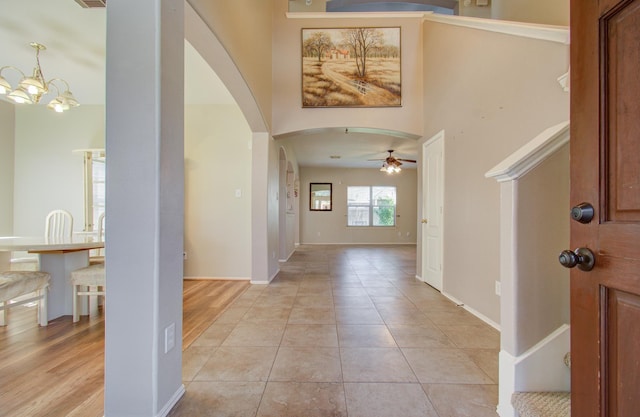18303 Melissa Springs Dr, Tomball, TX 77375 - foyer with baseboards, arched walkways, ceiling fan with notable chandelier, and light tile patterned floors