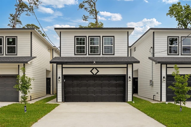 view of front of property featuring a garage, a shingled roof, and concrete driveway
