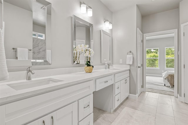 full bathroom with double vanity, a sink, and baseboards