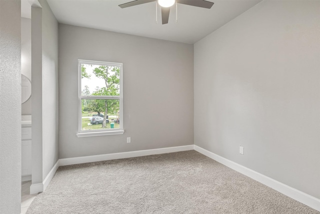 spare room featuring baseboards, ceiling fan, and light colored carpet
