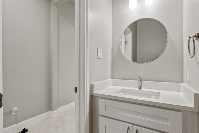 bathroom with vanity, baseboards, and marble finish floor