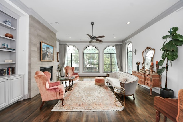403 W Pierce St W, Houston, TX 77019 - sitting room with crown molding, a tile fireplace, dark wood-type flooring, a ceiling fan, and built in shelves