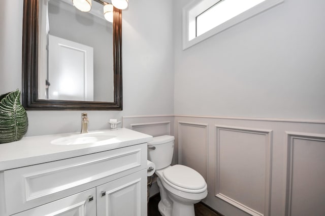 403 W Pierce St W, Houston, TX 77019 - half bathroom featuring toilet, vanity, a wainscoted wall, and a decorative wall