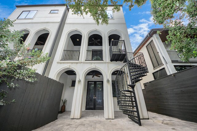 403 W Pierce St W, Houston, TX 77019 - doorway to property featuring french doors, a balcony, stucco siding, and fence