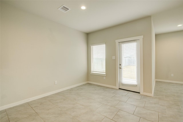 empty room featuring visible vents, recessed lighting, baseboards, and light tile patterned floors