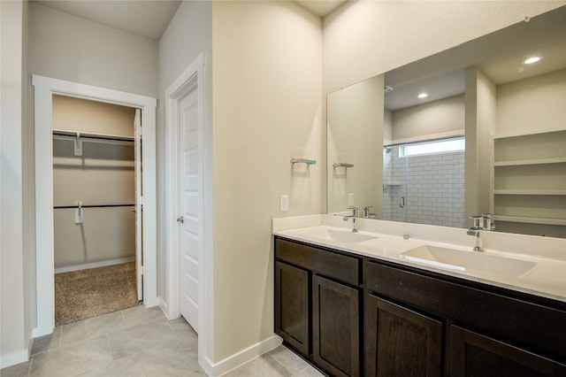 bathroom with baseboards, a sink, a stall shower, and a spacious closet