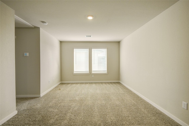 carpeted spare room with baseboards and visible vents