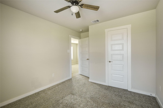 unfurnished bedroom with carpet flooring, a ceiling fan, baseboards, and visible vents