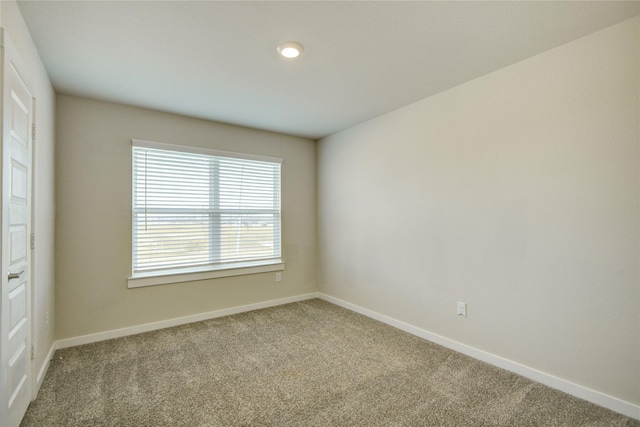 carpeted spare room featuring baseboards