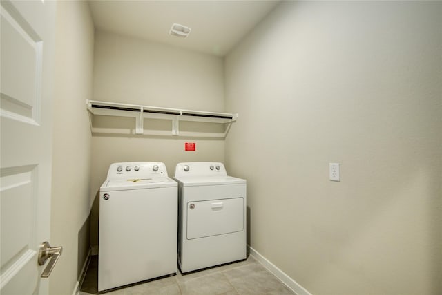 washroom featuring independent washer and dryer, laundry area, baseboards, light tile patterned floors, and visible vents