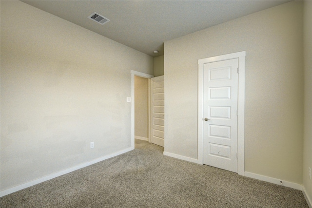 unfurnished bedroom featuring baseboards, visible vents, and carpet