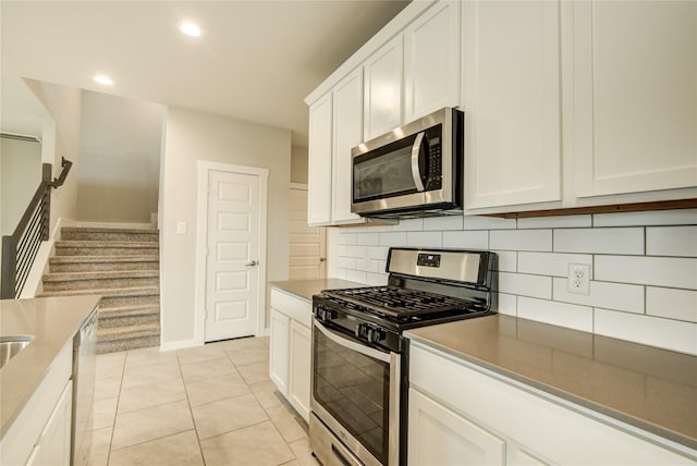 kitchen featuring light tile patterned flooring, recessed lighting, white cabinetry, appliances with stainless steel finishes, and backsplash