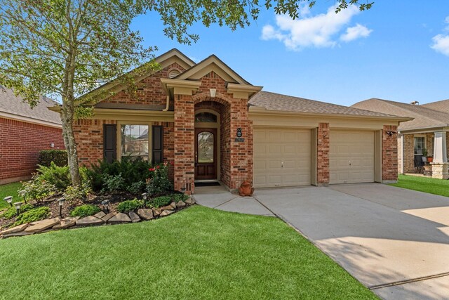 ranch-style house featuring a garage, concrete driveway, a front lawn, and brick siding