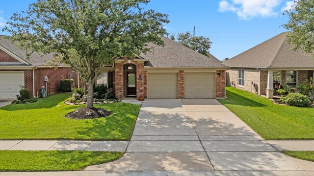 view of front of home with an attached garage, a front yard, driveway, and brick siding