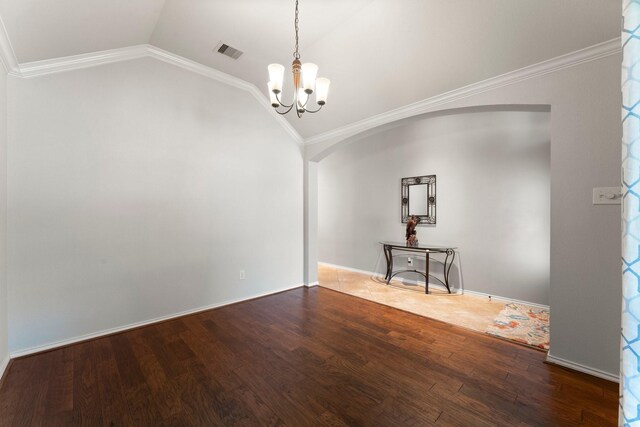 spare room featuring visible vents, arched walkways, wood finished floors, a notable chandelier, and lofted ceiling
