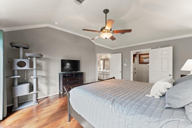 bedroom featuring vaulted ceiling, ornamental molding, wood finished floors, and visible vents
