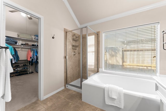 full bathroom with a walk in closet, a bath, tile patterned flooring, a shower stall, and ornamental molding