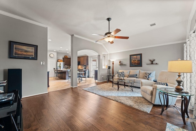 living area with crown molding, arched walkways, ceiling fan, and visible vents
