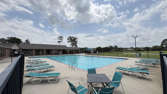pool featuring fence and a patio area