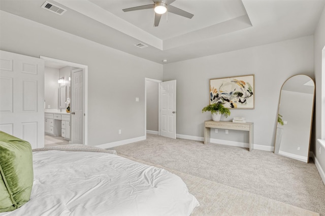 8161 Crestview Dr, Houston, TX 77028 - bedroom with a tray ceiling, light carpet, baseboards, ensuite bath, and a ceiling fan