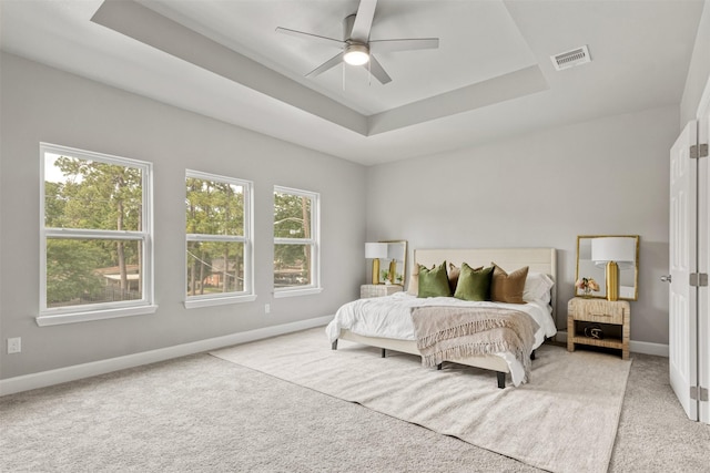 8161 Crestview Dr, Houston, TX 77028 - carpeted bedroom featuring multiple windows, baseboards, a tray ceiling, and ceiling fan