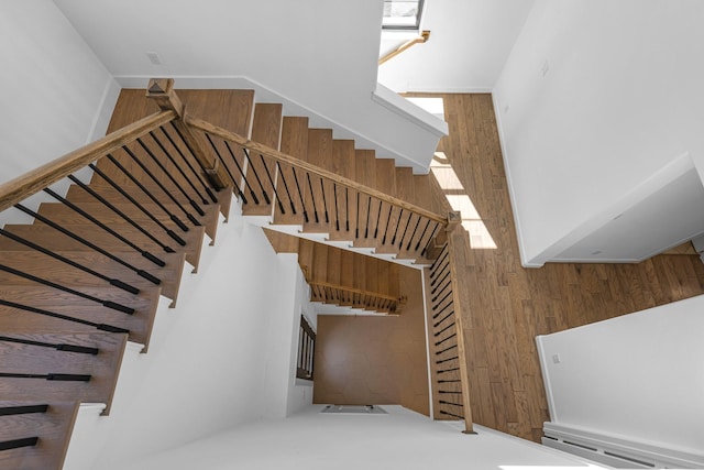 staircase featuring wood walls and a towering ceiling