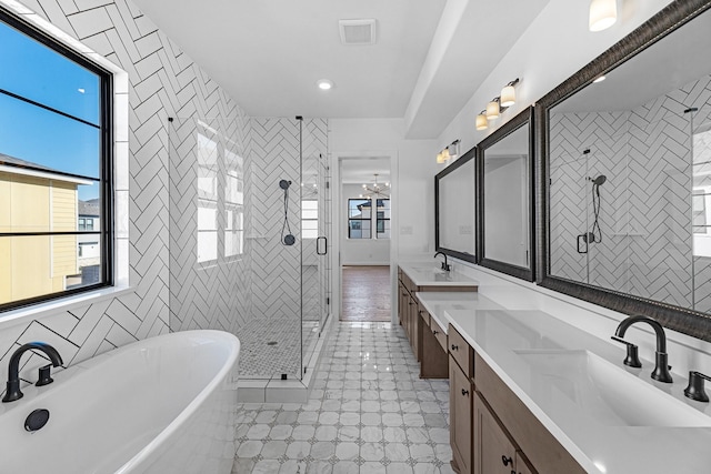 bathroom featuring plenty of natural light, a sink, double vanity, and a shower stall