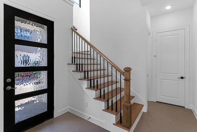tiled foyer featuring stairway, baseboards, and recessed lighting