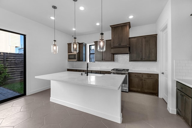 kitchen featuring decorative backsplash, dark brown cabinets, a sink, appliances with stainless steel finishes, and hanging light fixtures