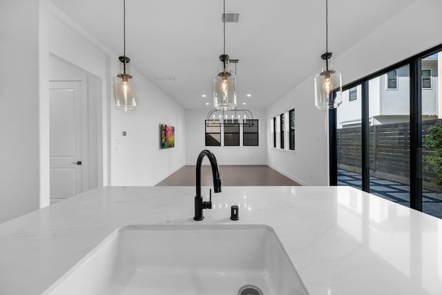 details featuring visible vents, a sink, decorative light fixtures, and light stone countertops