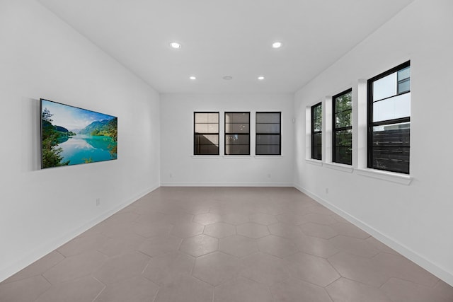 empty room featuring baseboards and recessed lighting
