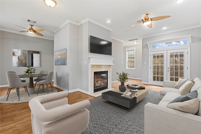 living area with ceiling fan, ornamental molding, and visible vents