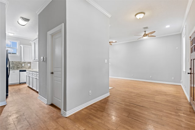 hall featuring baseboards, ornamental molding, light wood-type flooring, and visible vents