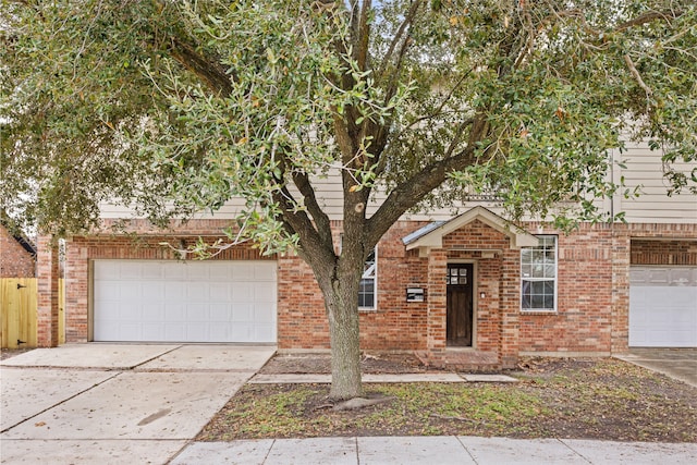 view of property hidden behind natural elements with concrete driveway, brick siding, and a garage