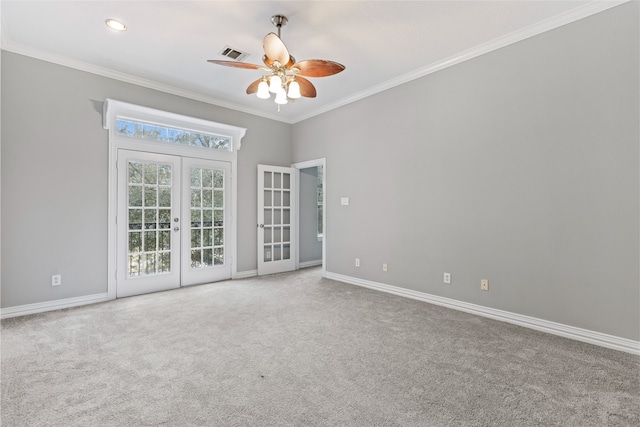 carpeted empty room with crown molding, visible vents, baseboards, ceiling fan, and french doors