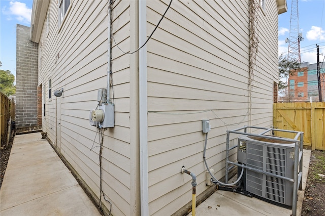 view of home's exterior featuring central air condition unit and fence