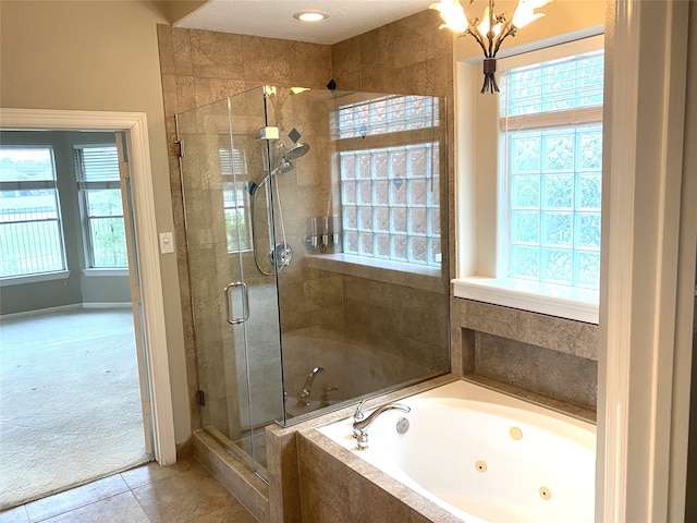 bathroom with plenty of natural light, a whirlpool tub, tile patterned flooring, and a shower stall