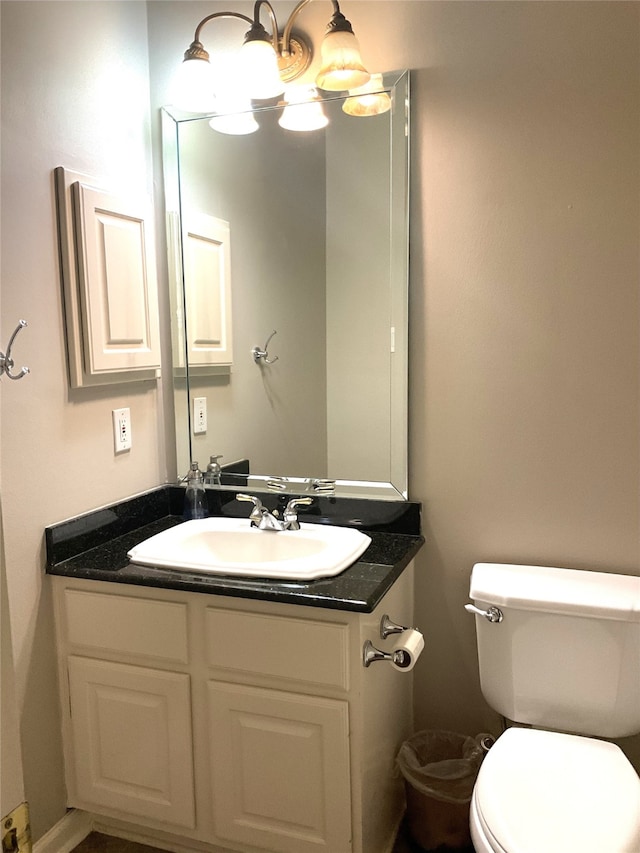 half bath featuring vanity and toilet