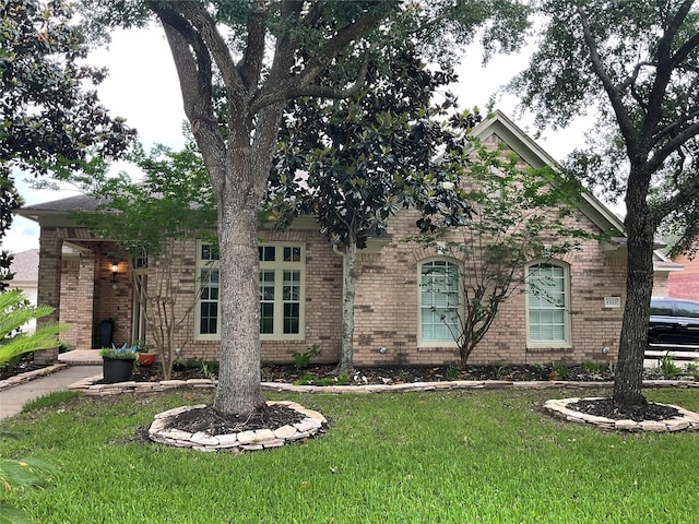 view of front of house with brick siding and a front lawn