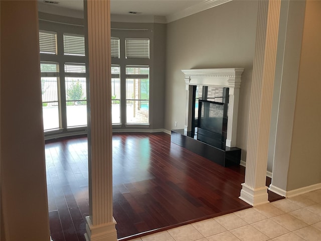 1322 Wellshire Dr, Katy, TX 77494 - unfurnished living room featuring decorative columns, wood finished floors, baseboards, crown molding, and a glass covered fireplace