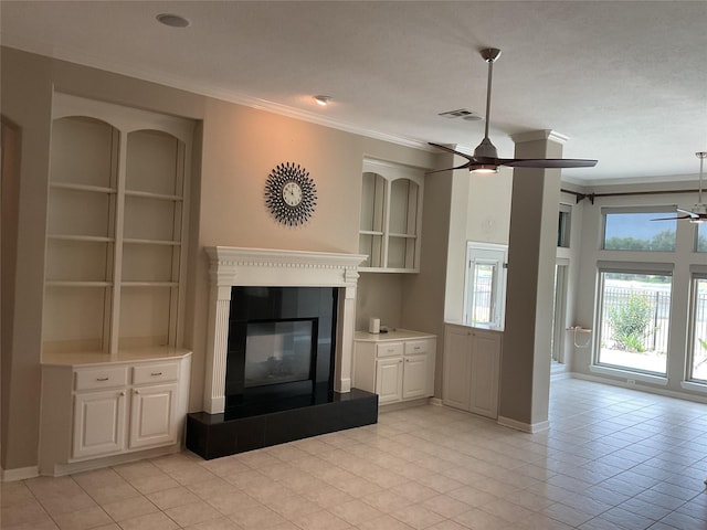 unfurnished living room with crown molding, visible vents, a glass covered fireplace, light tile patterned flooring, and ceiling fan