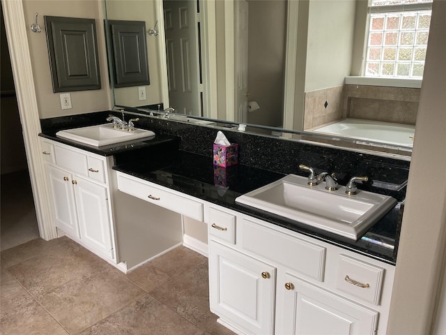 full bathroom featuring double vanity, a sink, and a garden tub