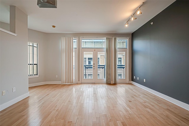 unfurnished room with light wood-style floors and baseboards
